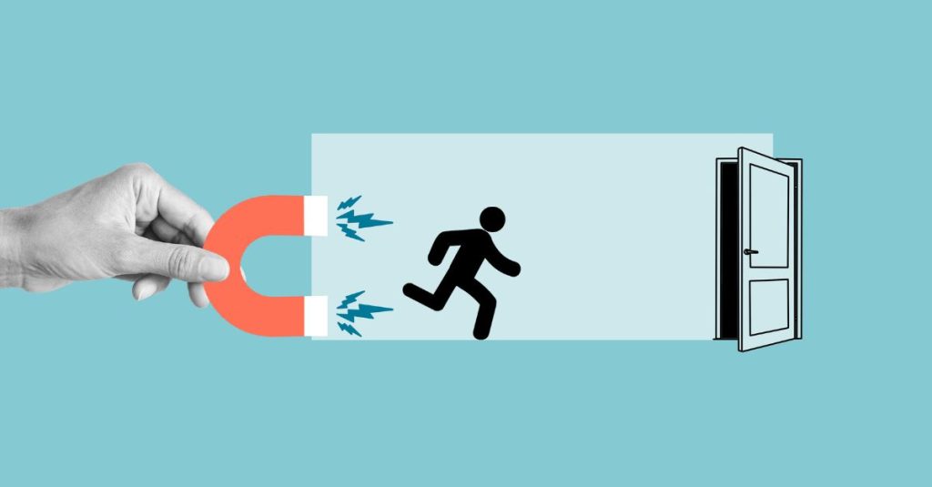A conceptual image showing a hand holding a red horseshoe magnet pulling back a black stick figure running toward an open door, symbolising employee retention or preventing turnover. The background is light blue, creating a clean and modern visual style.